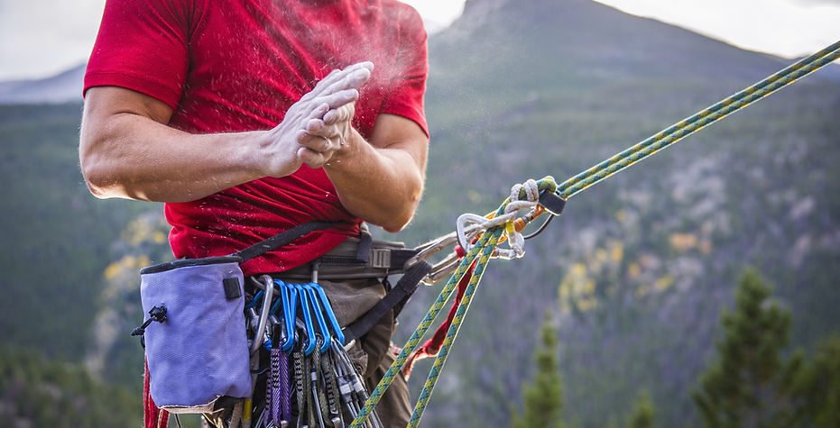 El escalador de roca espolvoreado de Manos